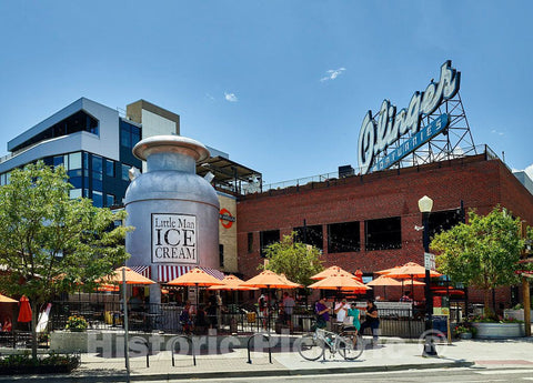 Photo - an odd juxtaposition in Denver, Colorado: a Popular ice Cream Stand in an Oversized Milk can, Beneath a Parking Garage on which Sits a Local Landmark